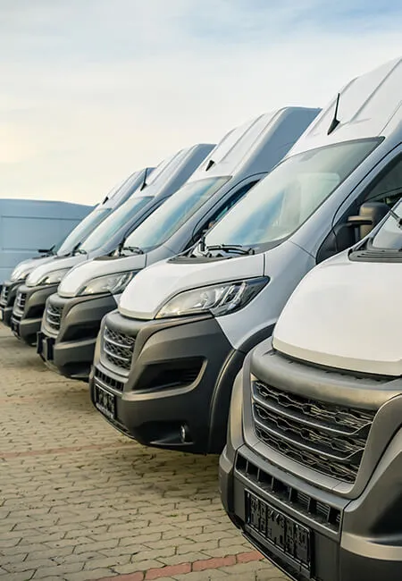 Fleet of white delivery vans parked in line.